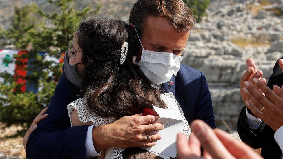 French President Emmanuel Macron hugs a victim of the Beirut blast after planting a cedar tree in Jaj, Lebanon (1 September 2020)