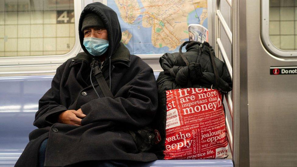 A homeless man carrying his belongings rides the subway December 30, 2020 in New York City. It is estimated that among New York City's nearly 80,000 homeless, there are every night 4,000 people sleeping on the the city's streets, in subways and in other public spaces