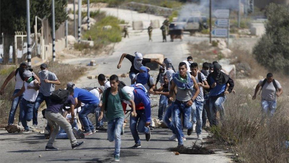 Palestinian protesters run during clashes with Israeli troops near Ramallah (05/10/15)