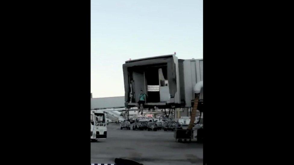 Man sitting at end of disconnected boarding tunnel