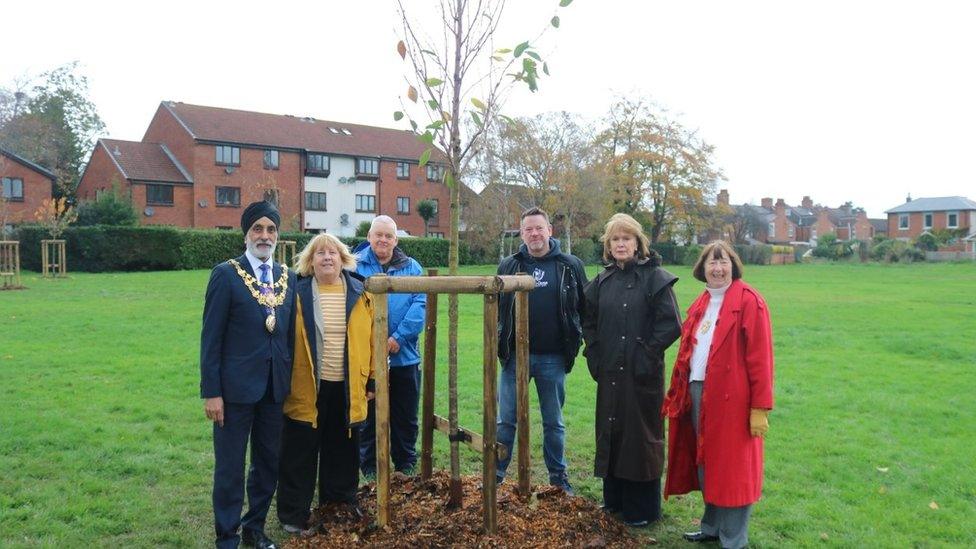 Councillors standing around cherry tree