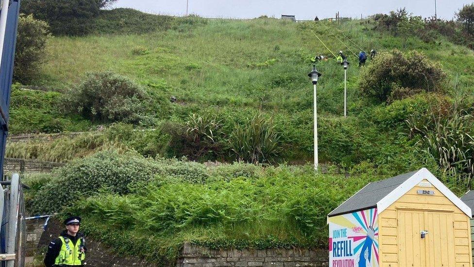 Search teams on ropes scour the cliffs for evidence