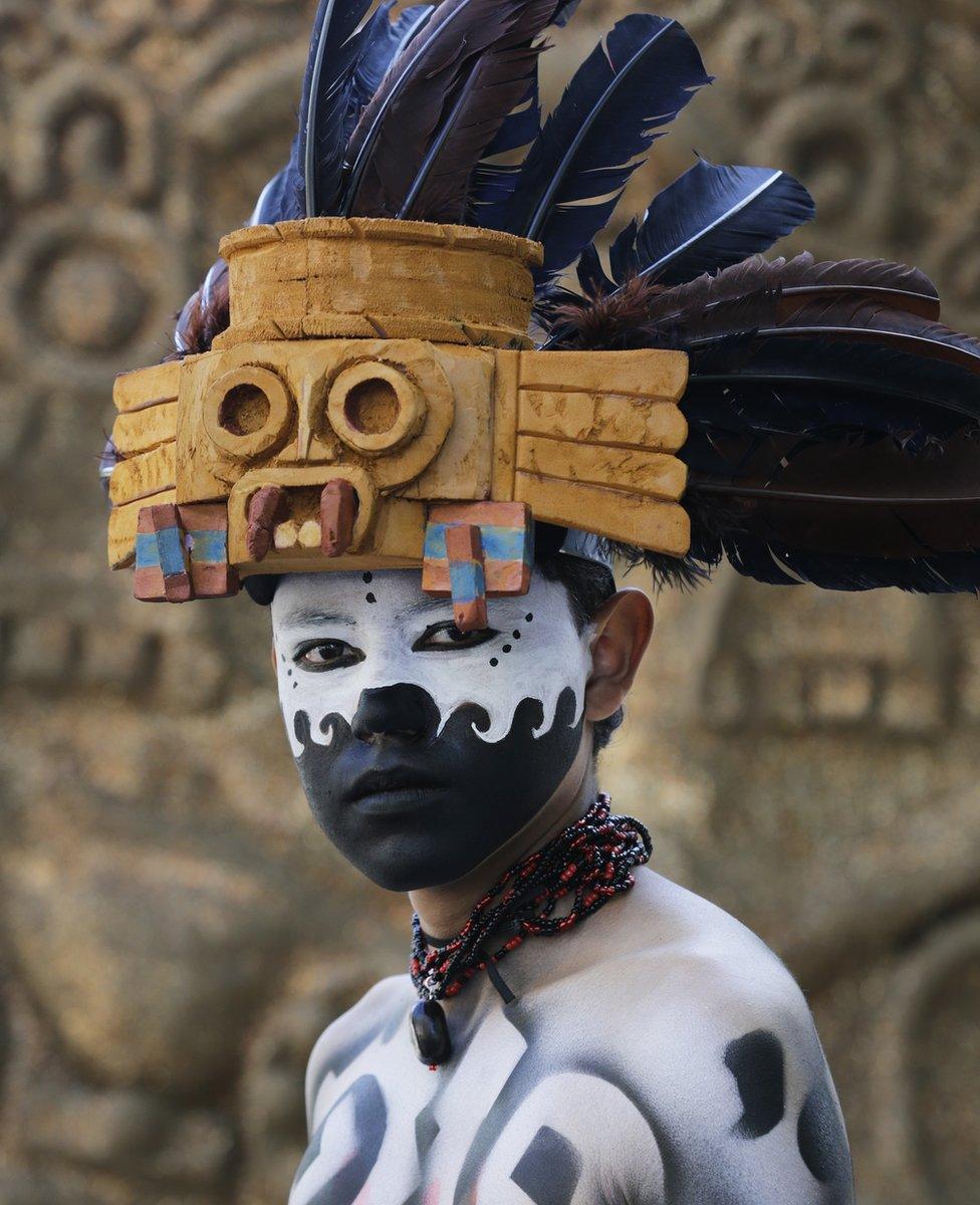 Man dressed and painted in pre-Columbian attire awaits start of Day of the Dead parade along Mexico City's main Reforma Avenue, Saturday, Oct 29, 2016