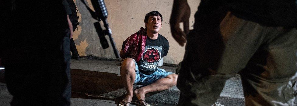 Philippine Drug Enforcement Agency (PDEA) agents and police arrest an alleged drug dealer during a drug raid