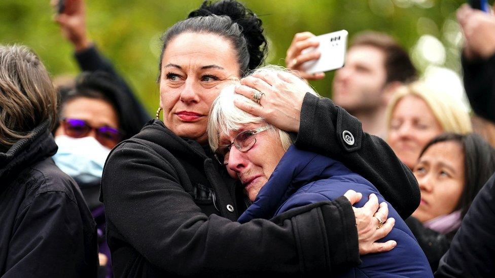 People crying while watching the funeral