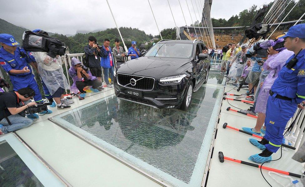 A car is driven over a glass bridge in Zhangjiajie, (June 2016)