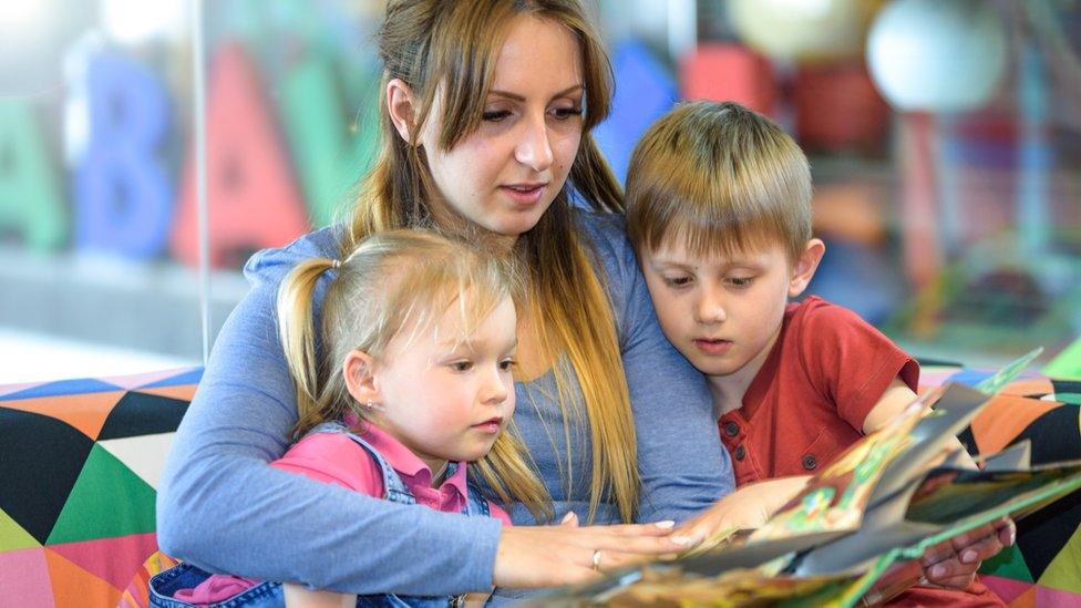 Au pair reading to two children