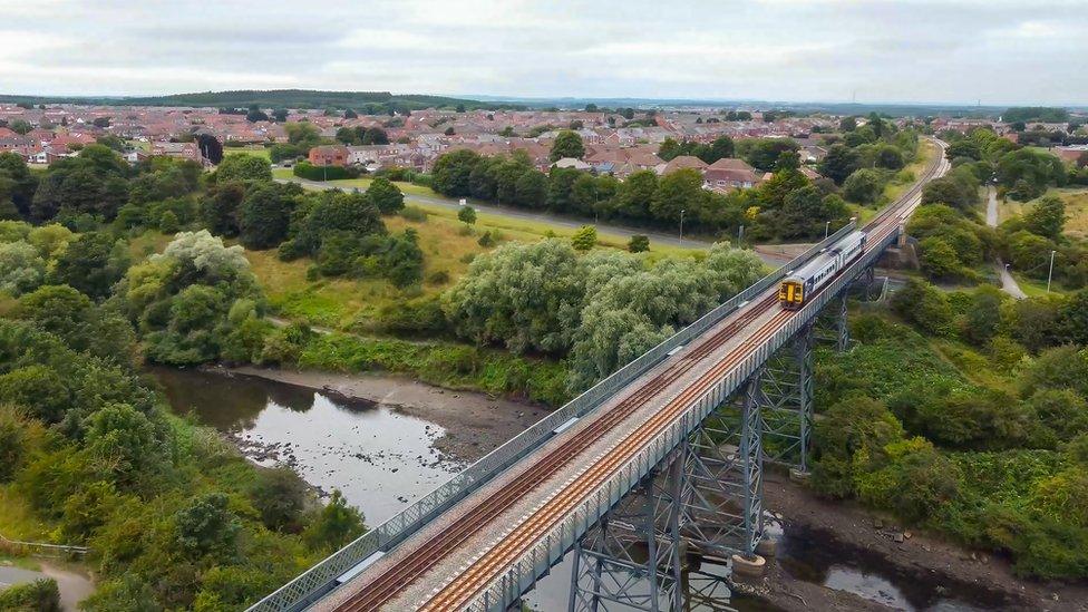 A train crosses a bridge over a river