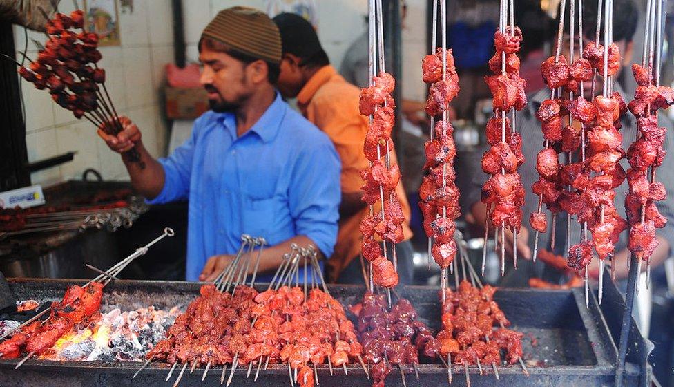 An Indian Muslim vendor grills meat kebabs over burning coals at a roadside stall in preparation for Muslims breaking their fast at sundown in Mumbai on August 19, 2010.