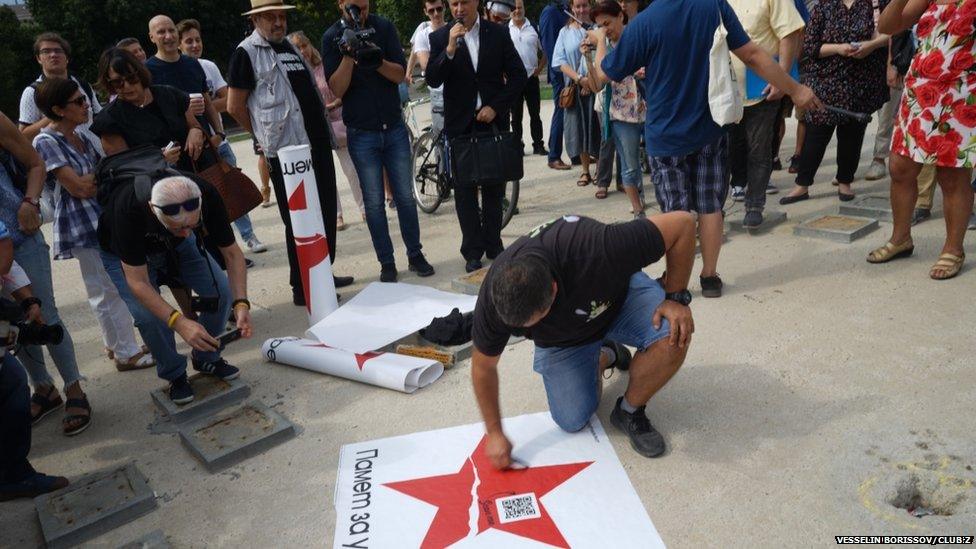 Protesters placing broken star signs outside buildings