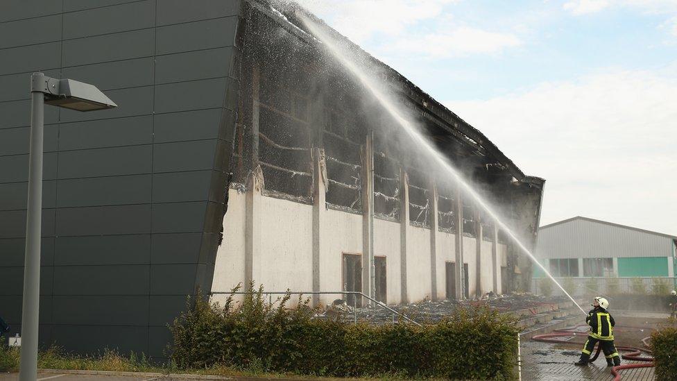 Firemen put out fire at a sports hall intended to house refugees in Nauen, Germany on 25 August 2015