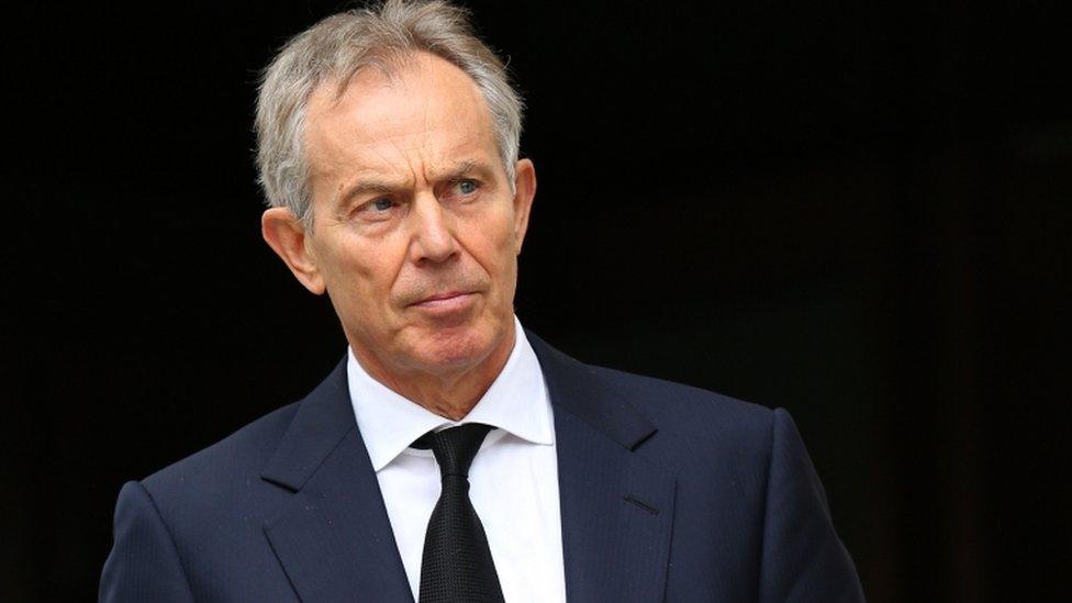 Tony Blair in front of a black background, in a photograph from 2012