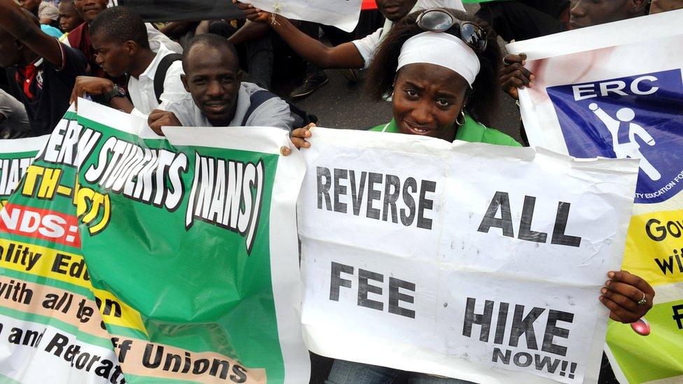 Students and workers carry placards as they sit on the Lagos-Ikorodu highway to protest against the suspension of academic activities