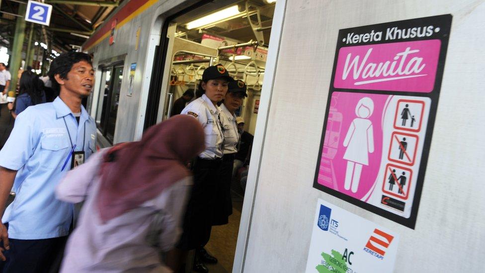 A passenger boards a women-only train coach of the state railway PT Kereta Api Indonesia at Jakarta station