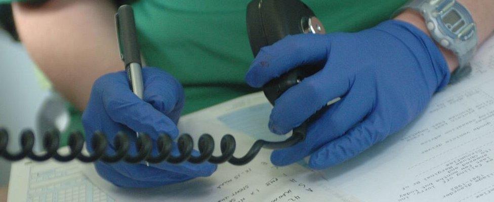 Paramedic writing up notes in an ambulance