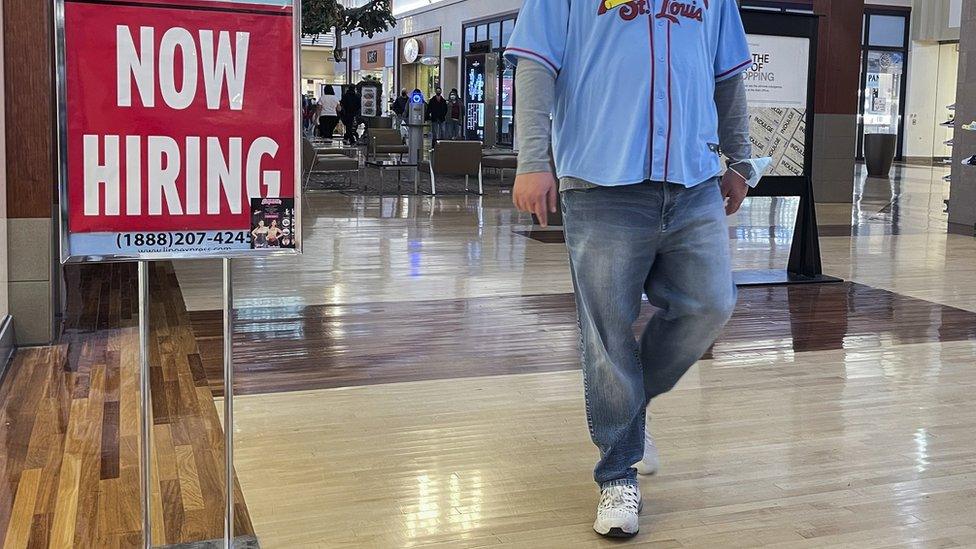 A help wanted sign appears outside a store in a shopping mall in Gurnee, Illinois, USA, 03 December 2021.