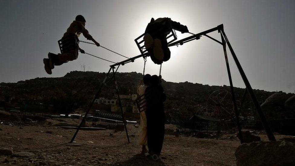 Afghan children play on swings in the old city of Kabul (September 2010)