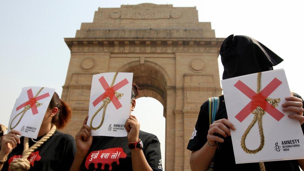 Activists of Amnesty International India wear black hoods and a noose around their necks as they protest against the death penalty, in New Delhi in October 2008