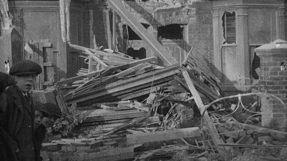 Boy in front of bomb damaged