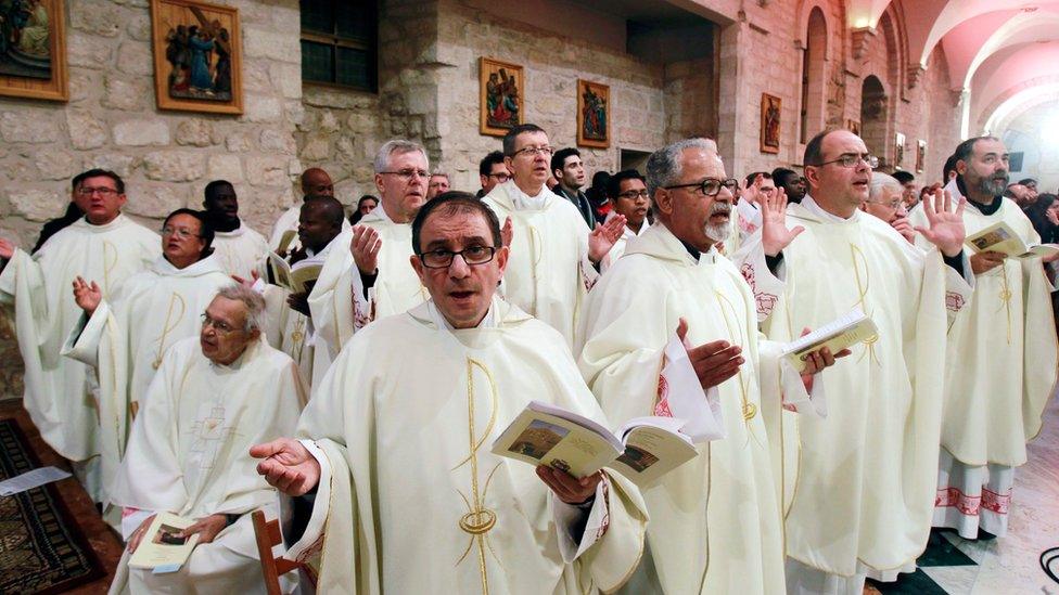 Latin clergies pray as they walk to the Grotto at the end of the Christmas Midnight Mass in Saint Catherine's Church at the Church of the Nativity in Bethlehem, West Bank, 25 December 2016