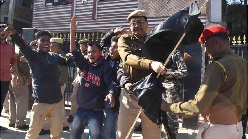 Assam Police personnel remove black flags from Krishak Mukti Sangram Samiti (KMSS) activists protesting with 69 other indigenous organizations of Assam during a demonstration against the Citizenship Amendment Bill 2016,