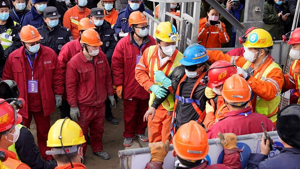 One (C-blue helmet) of twenty-two Chinese miners is saved from hundreds of metres underground where they had been trapped for two weeks after a gold mine explosion in Qixia, in eastern China's Shandong province on January 24, 2021.