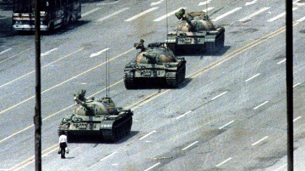 Famous Tank Man image shows a lone man with shopping bags standing in front of a row of tanks