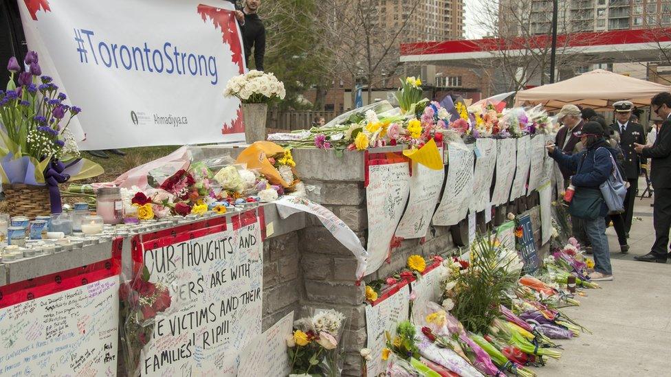 People attend a makeshift memorial across the street from where a man in a rented van hit pedestrians on Yonge Street in northern Toronto, Canada, 24 April 2018.