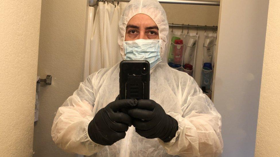 José Zaragoza in his cleaning gear, including a full body coverall, gloves and a mask