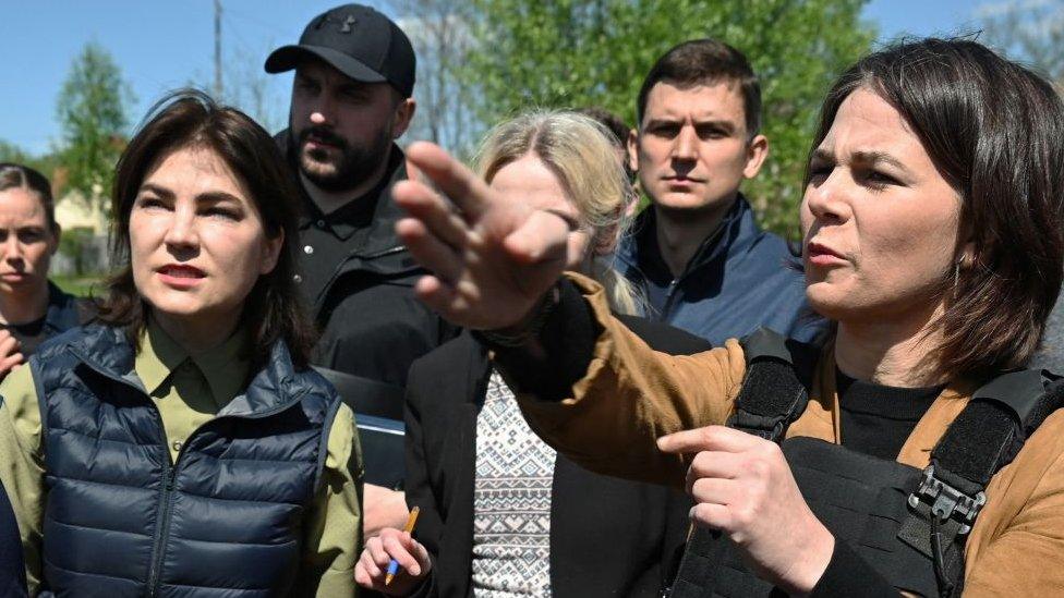 German Foreign Minister Annalena Baerbock (R) and Ukraine's Prosecutor General Iryna Venediktova (L) attend outside St. Andrew and Pyervozvannoho All Saints church at the former mass grave of civilian people in Bucha, northwest of Kyiv, on May 10, 2022