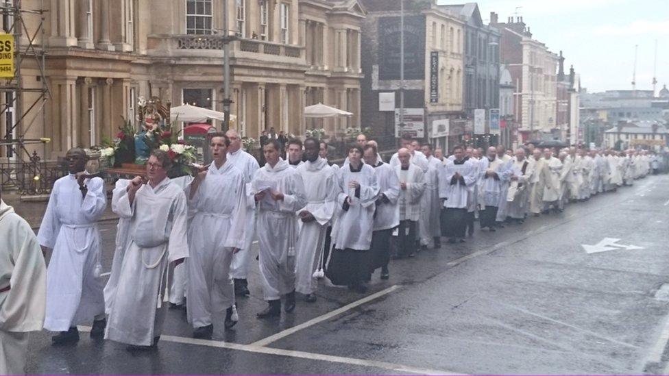 priests parade in white