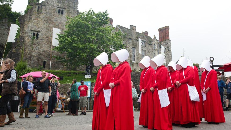 Handmaids outside the festival