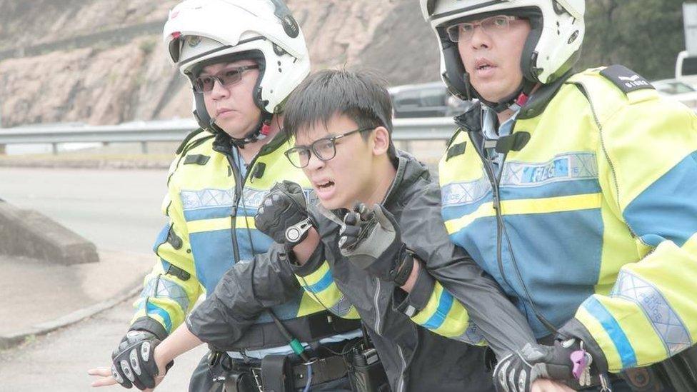 A student activist being held by police