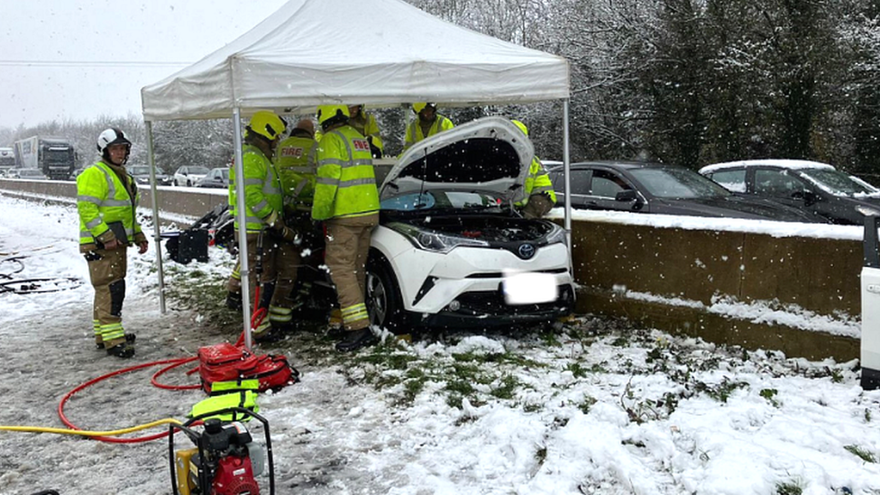 Firefighters help occupants of a car caught up in a crash on the M5