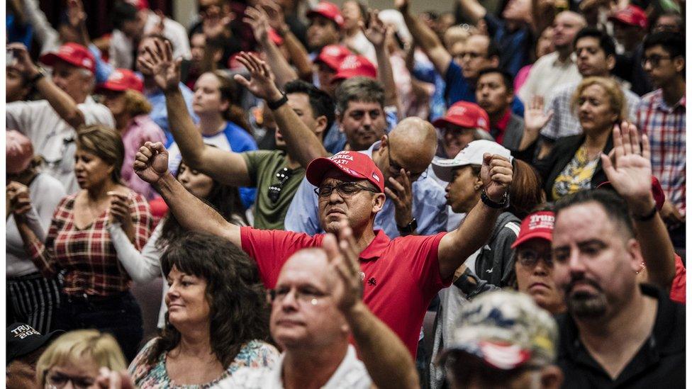 Attendees pray together before President Donald Trump addresses the crowd at the King Jesus International Ministry during a "Evangelicals for Trump" rally in Miami