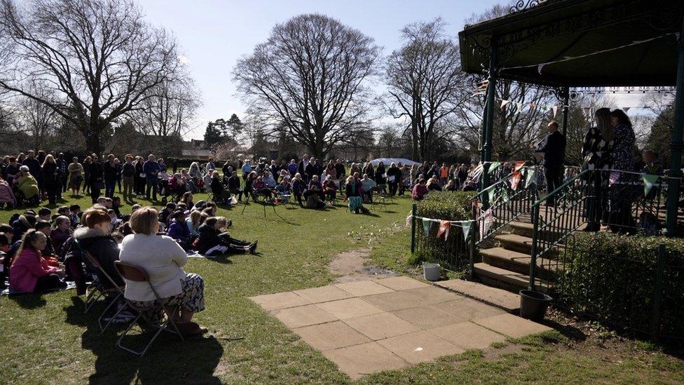 A group of people at a memorial in a park