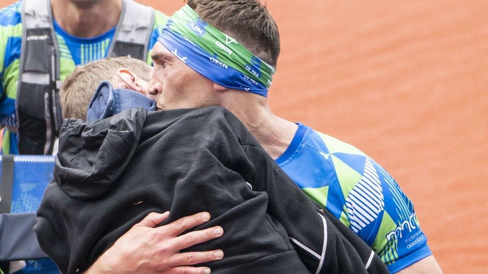 Kevin Sinfield kissing Rob Burrow on the cheek as they cross the finish line