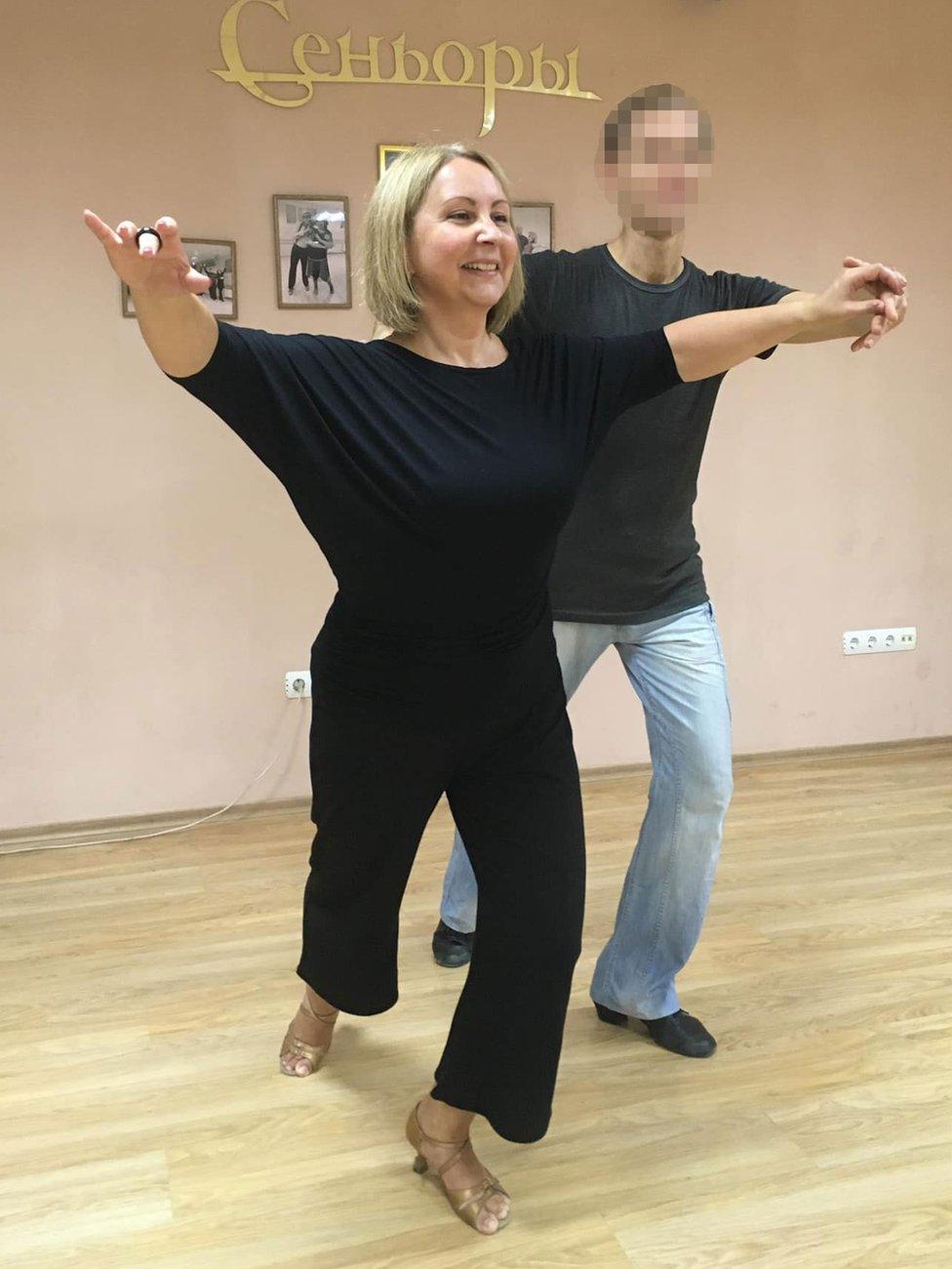 Svetlana Koval practises ballroom dancing with a partner, whose face has been blurred to keep him anonymous.