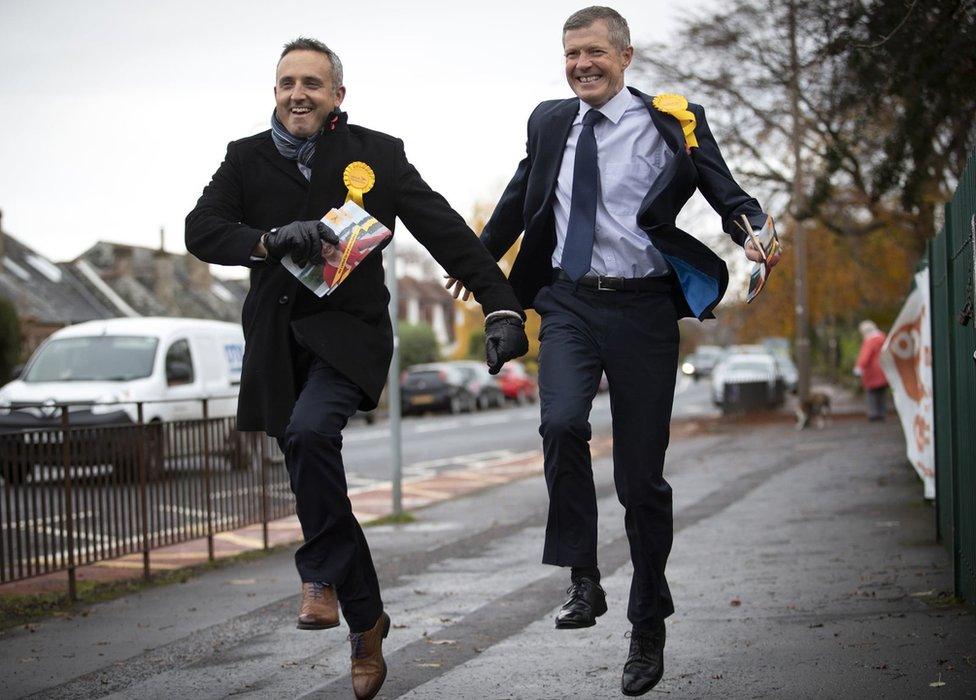 Scottish Liberal Democrat leader Willie Ronnie (right) and party general election campaign chairman Alex Cole-Hamilton skip down a street