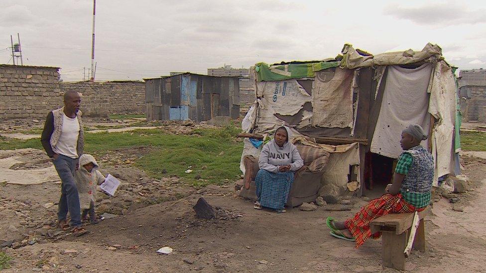 Catherine Kanini in front of her shack