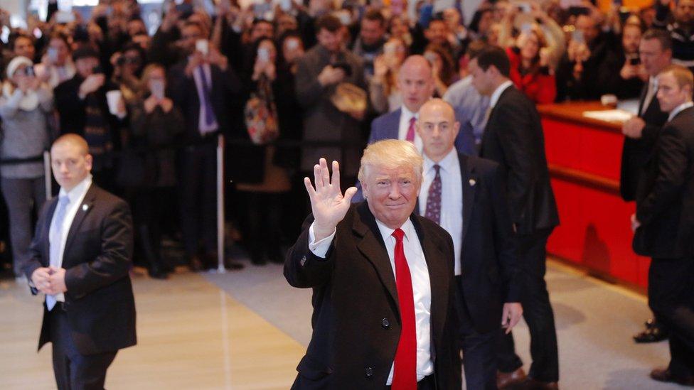 U.S. President elect Donald Trump reacts to a crowd gathered in the lobby of the New York Times building after a meeting in New York, U.S., November 22, 2016