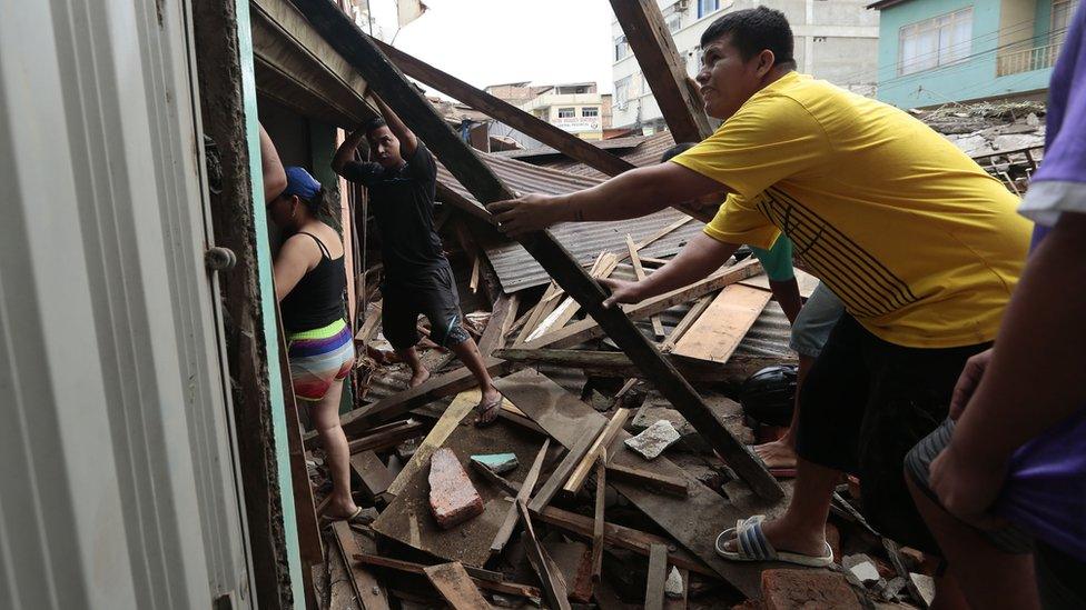 People clear rubble after an earthquake in Ecuador