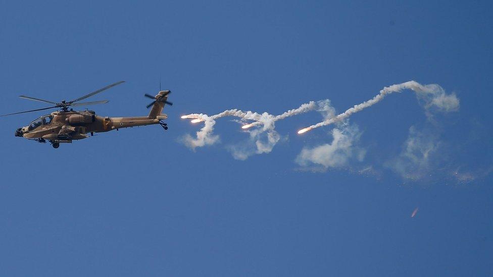 An Israeli Apache helicopter releases flares during a raid in the West Bank city of Jenin (19 June 2023)