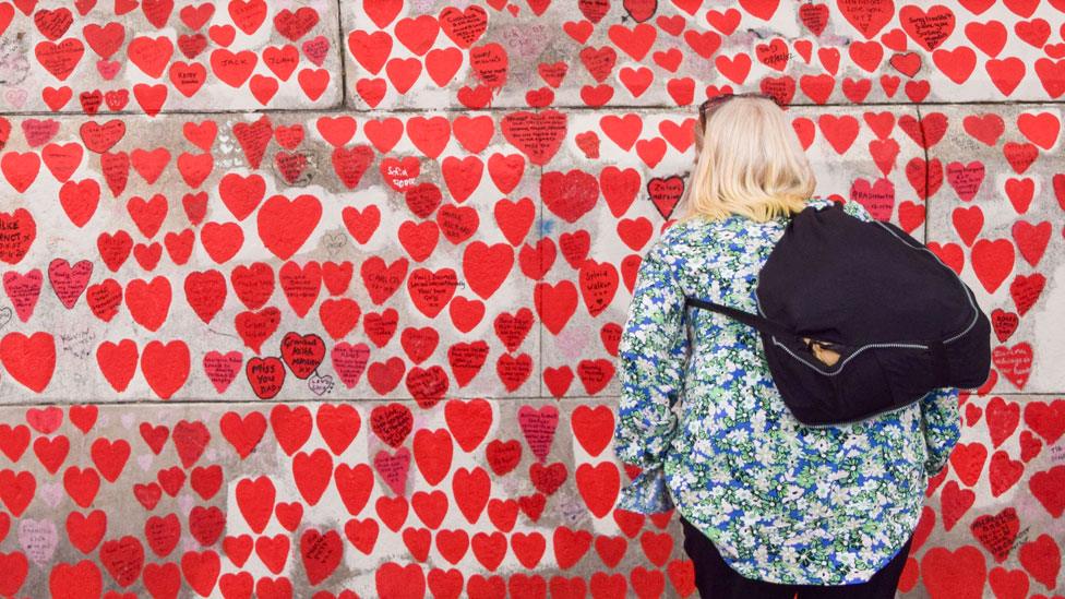 A woman reads the tributes on the National Covid Memorial Wall on 20 June 2023