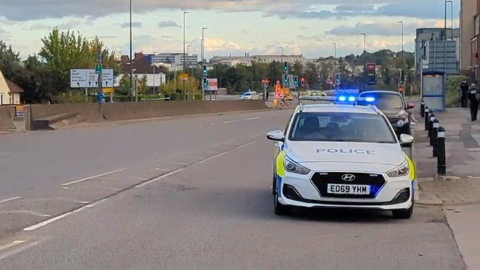 A police car and cordoned-off area