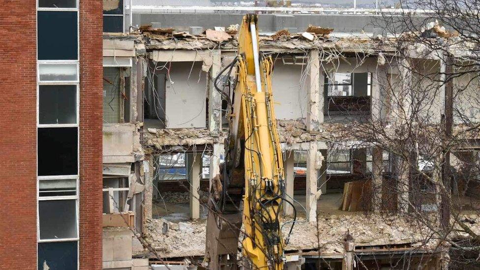 Crane demolishing building