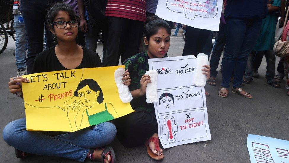 Indian students hold posters and sanitary napkins during a protest over a 12% tax on sanitary pads as part of the Goods and Services Tax (GST) in Kolkata on June 16, 2017.