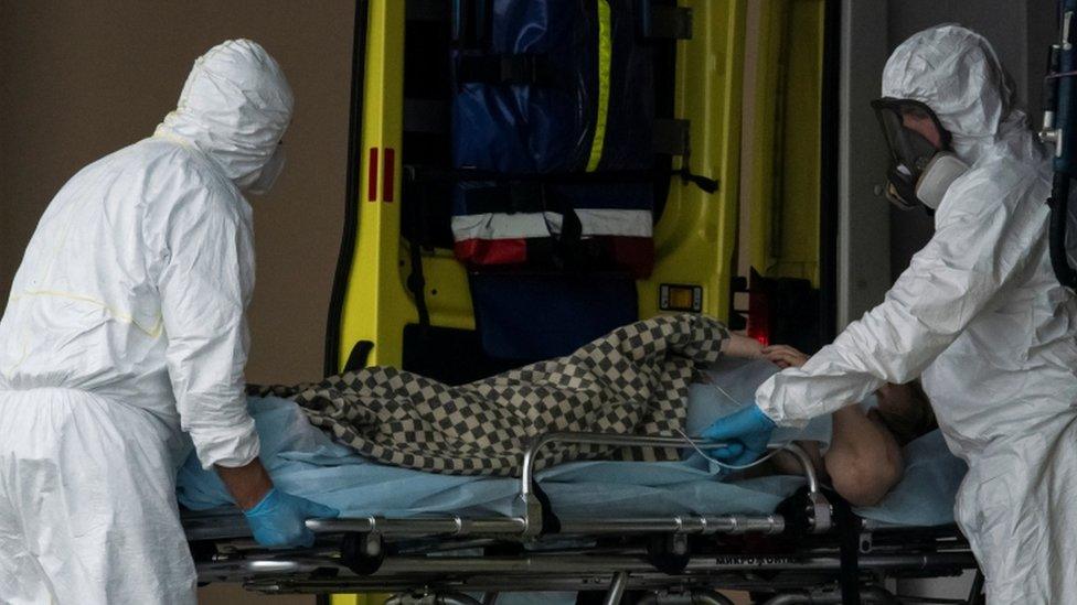 Medical specialists transport a person on a stretcher outside a hospital on the outskirts of Moscow on 12 May