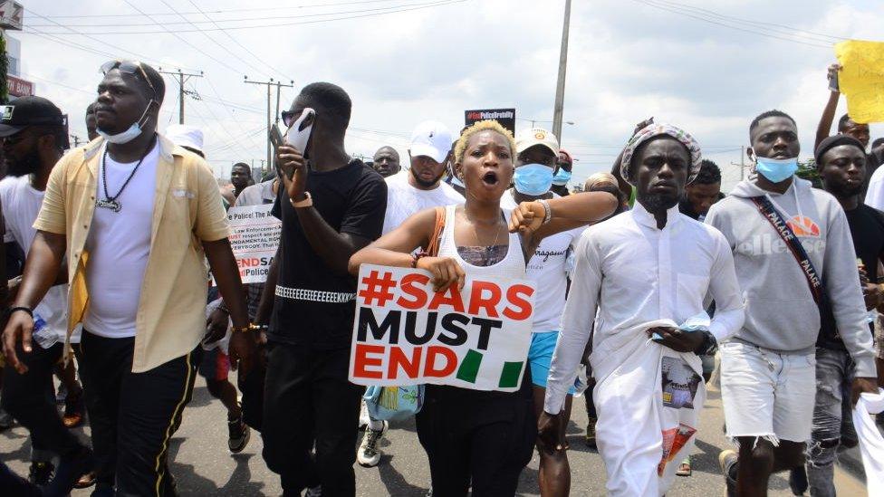 Youths of ENDSARS protesters display their placards in a crowd in support of the ongoing protest against the harassment, killings and brutality of The Nigerian Police Force Unit called Special Anti-Robbery Squad (SARS) at Allen Roundabout in Ikeja, on October 13, 2020.