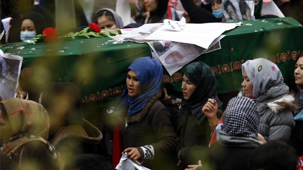 Protesters carry a green-draped coffin through Kabul